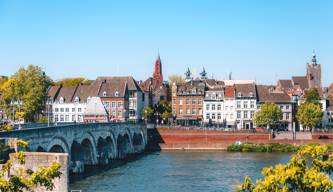 Renaissance-era buildings overlooking a river and broad pedestrian bridge.